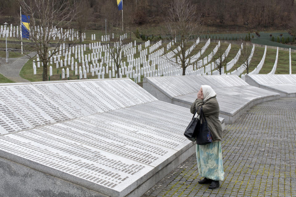 FILE - In this Wednesday, March 20, 2019 file photo, a woman prays at the Potocari memorial center for victims of the Srebrenica genocide, in Potocari, Bosnia and Herzegovina. The Dutch Supreme Court is ruling Friday July 19, 2019 in a long-running legal battle over whether the Netherlands can be held liable in the deaths of more than 300 Muslim men who were murdered by Bosnian Serb forces during the 1995 Srebrenica massacre. (AP Photo/Marko Drobnjakovic, File)