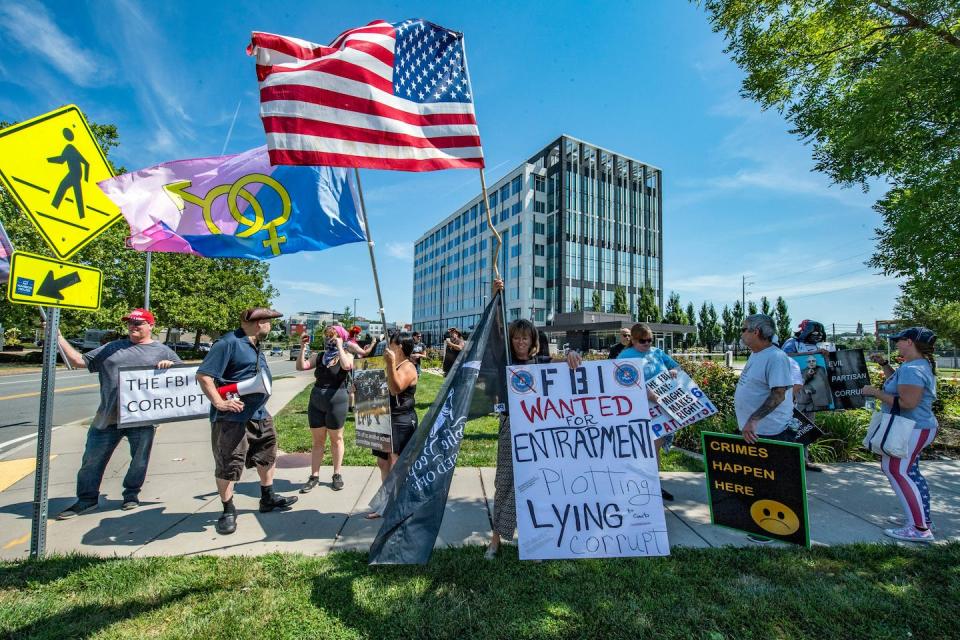 Demonstrators protest the FBI’s recent raid of Mar-a-Lago outside the agency’s Chelsea, Mass., building on Aug. 21, 2022. <a href="https://media.gettyimages.com/photos/demonstrators-wave-flags-and-hold-signs-as-they-protest-the-recent-picture-id1242639842?s=2048x2048" rel="nofollow noopener" target="_blank" data-ylk="slk:Joseph Prezioso/AFP via Getty Images;elm:context_link;itc:0;sec:content-canvas" class="link ">Joseph Prezioso/AFP via Getty Images</a>