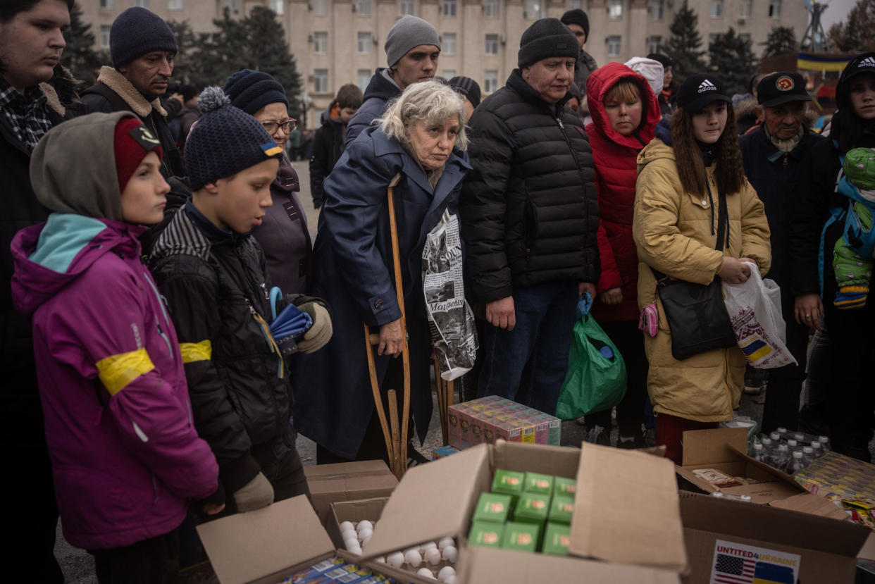 Residents crowd around volunteers to receive humanitarian food aid in Kherson central square on Nov. 20, 2022 in Kherson, Ukraine.