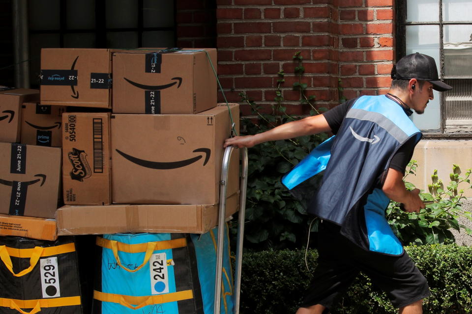 An Amazon delivery worker pulls a delivery cart full of packages during its annual Prime Day promotion in New York City, U.S., June 21, 2021. REUTERS/Brendan McDermid