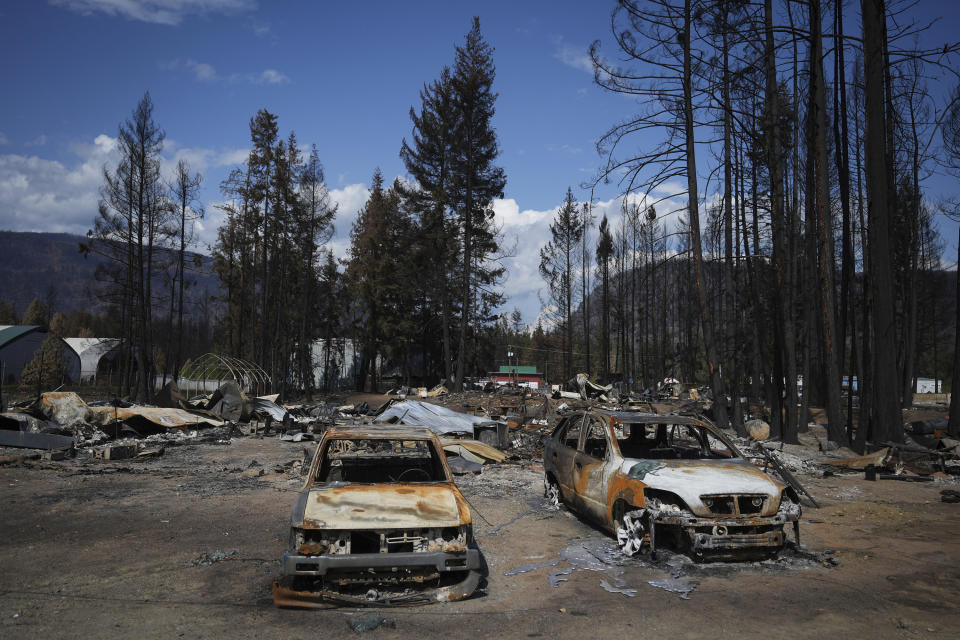 Burned vehicles and other debris are scattered about a property destroyed by the Bush Creek East wildfire, in Scotch Creek, British Columbia, Canada, on Sept. 6, 2023. (Darryl Dyck/The Canadian Press via AP)