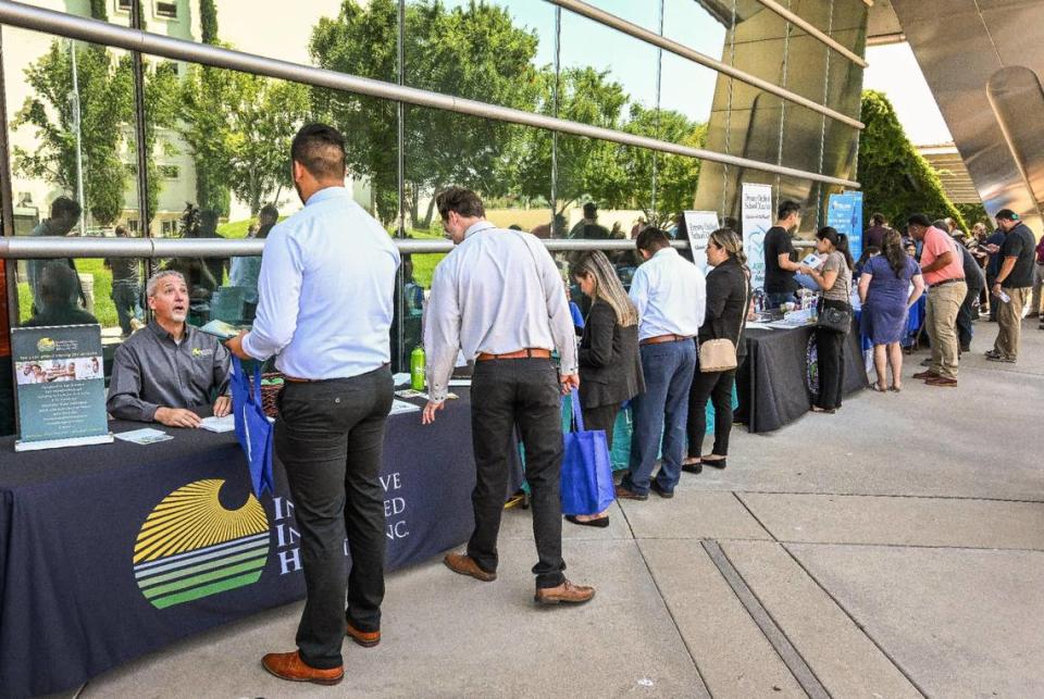 Job-seekers stop to speak with dozens of prospective employers during a job fair hosted by Workforce Connection and the City of Fresno in response to the laying off of 300 Fresno employees from Bitwise Industries, at Fresno City Hall on Friday, June 16. 2023. CRAIG KOHLRUSS/ckohlruss@fresnobee.com