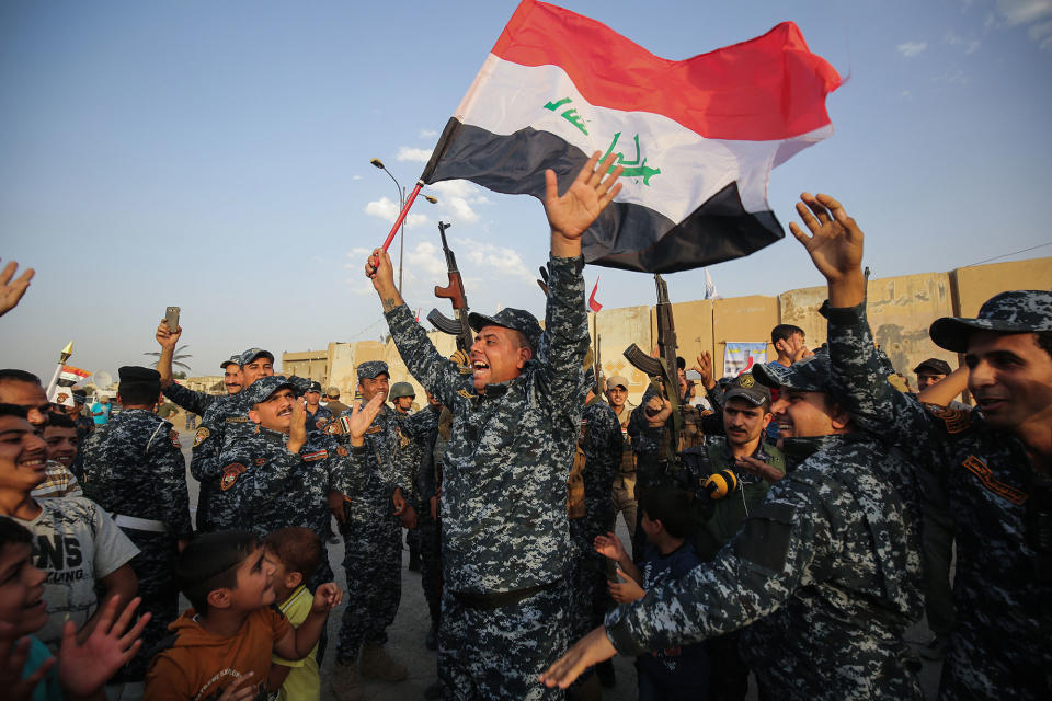 <p>JUL. 2, 2017 – Members of the Iraqi federal police dance with children and a national flag during a celebration in the Old City of Mosul, where the gruelling battle to retake Iraq’s second city from Islamic State (IS) group fighters is now nearing its end, on July 2, 2017. (Photo: Ahmad al-Rubaye/AFP/Getty Images) </p>