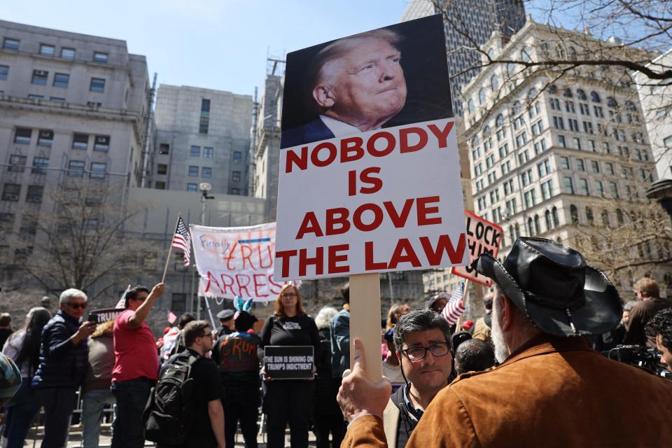 People protesting against former President Donald Trump gather outside of the Manhattan Criminal Court before his arraignment on April 4, 2023, in New York City.