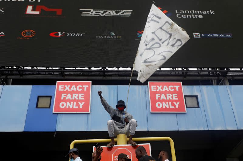 A demonstrator carries a flag and gestures during a protest over alleged police brutality, in Lagos