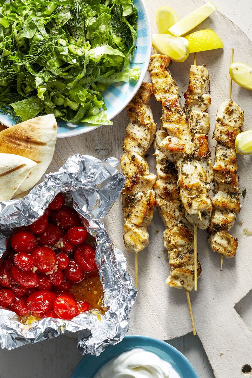 chicken souvlaki skewers with a side tomatoes in foil