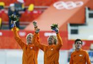 Winner Michel Mulder of the Netherlands (C), his twin brother second-placed Ronald Mulder (L), and their compatriot third-placed Jan Smeekens celebrate during the flower ceremony for the men's 500 metres speed skating race at the Adler Arena during the 2014 Sochi Winter Olympics February 10, 2014. REUTERS/Issei Kato (RUSSIA - Tags: OLYMPICS SPORT SPEED SKATING)