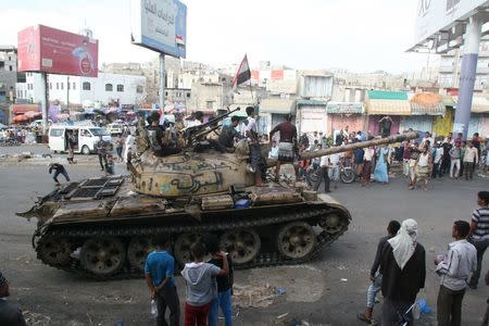 Pro-government fighters ride on a tank in the Bir Basha neighbourhood after they took the area from Houthi fighters in Yemen's southwestern city of Taiz March 11, 2016. REUTERS/Anees Mahyoub