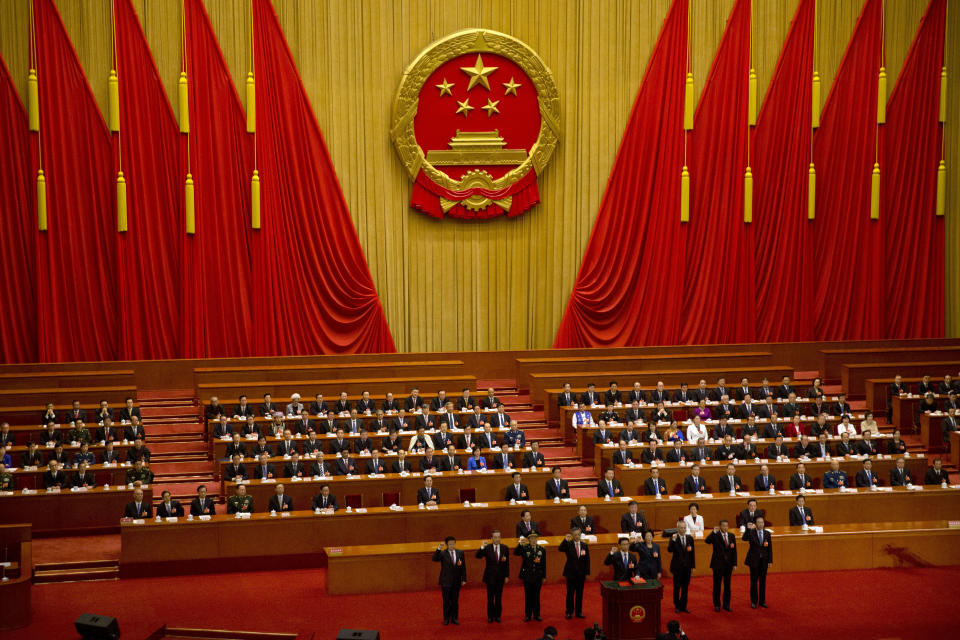 FILE - In this March 19, 2018, file photo, newly-appointed officials take the oath of office during a plenary session of China's National People's Congress (NPC) at the Great Hall of the People in Beijing. A new defense intelligence assessment lays out U.S. concerns about China's growing military might, underscoring worries that Beijing could decide it has the ability to attack Taiwan and win. (AP Photo/Mark Schiefelbein, File)