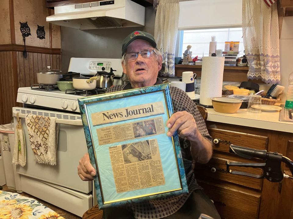 Manuel Noble holds up a framed Mansfield News Journal story about him and his wife from Nov. 22, 2013.