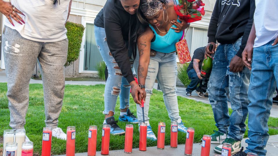 Angela Washington lights a candle for her son, Eric Gregory Brown III, during a vigil in Long Beach on May 10.  - Thomas R. Cordova/Long Beach Post