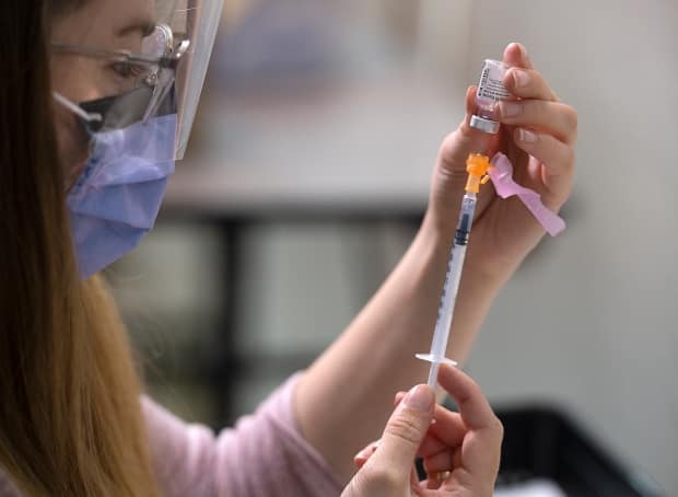 Allison Downing, a registered nurse, prepares the Pfizer-BioNtech COVID-19 vaccine at a vaccination clinic in Dartmouth, N.S. (Andrew Vaughan/The Canadian Press - image credit)