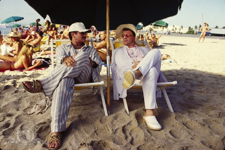 Two men sit on a beach in The Birdcage.