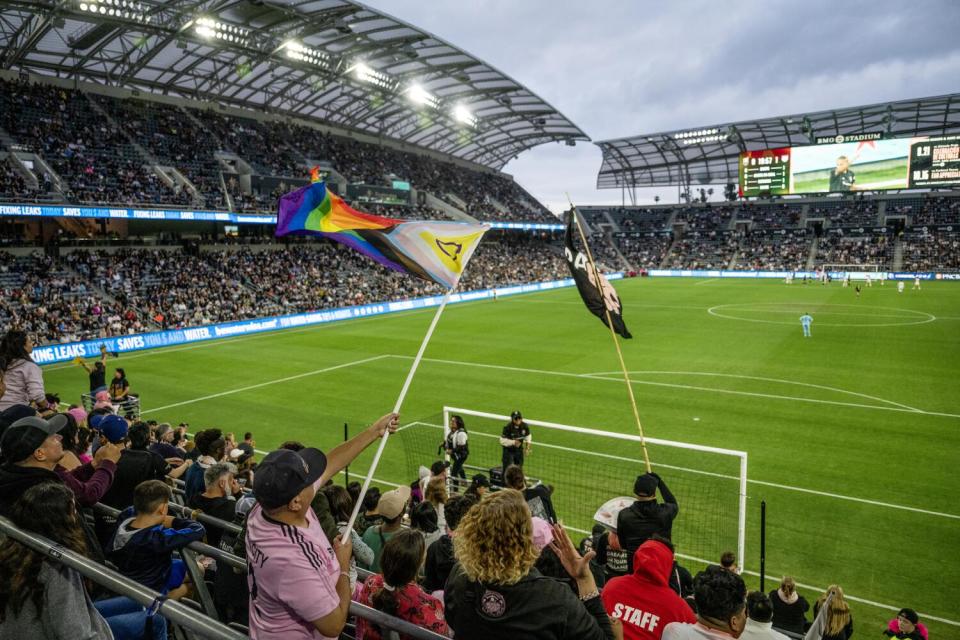 Angel City FC soccer fans wave Pride and team flags during a match against the Chicago Red Stars