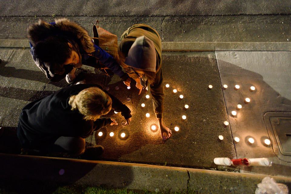 <p>Amauria Hawkins, right, lights candles spelling out ”ZOE,” the nickname of their friend Stephon Clark, during a candlelight vigil for Clark at the intersection of Florin and 29th Street on Friday, March 23, 2018 in Sacramento, Calif. (Photo: Paul Kitagaki Jr./Sacramento Bee via ZUMA Wire) </p>