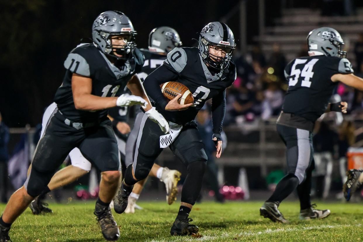 South Side's Ryan Navarra (0) runs the ball behind lead blocker Slayton Williams (11) during the first half against Rochester Friday night at South Side Area High School.