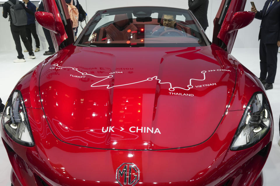 Visitors check at an MG car during the opening of China Auto Show in Beijing, China, Thursday, April 25, 2024. (AP Photo/Tatan Syuflana)