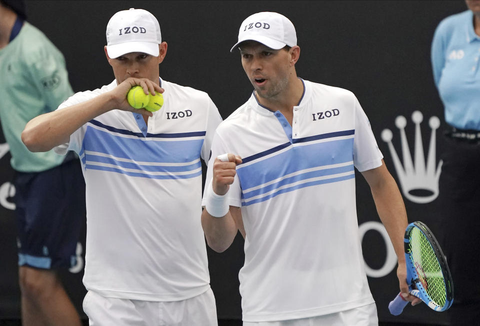 FILE - In this Jan. 22, 2020, file photo, Bob, left, and Mike Bryan talk during their first round doubles match against India's Rohan Bopanna and Japan's Yasutaka Uchiyama at the Australian Open tennis championship in Melbourne, Australia. Any World TeamTennis player or coach who tests positive for COVID-19 when arriving for the three-week 2020 season will be dropped from the league without pay. The health plan released Tuesday, June 16, 2020, by the WTT for its matches starting July 12 at The Greenbrier in West Virginia also calls for two daily temperature checks for spectators, no ball kids, a chair umpire aided by electronic line-calling instead of line judges, and no high-fives or handshakes between opponents. The rosters announced for the WTT's nine teams include Grand Slam title winners Kim Clijsters, Sloane Stephens, Sofia Kenin and the Bryan brothers. (AP Photo/Lee Jin-man, File)