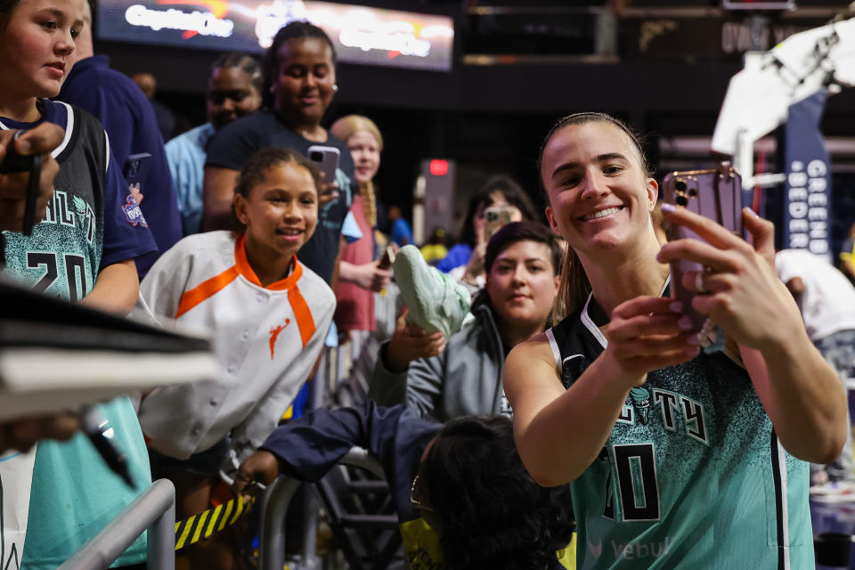 Sabrina Ionescu takes a selfie with fans after the win. (Scott Taetsch/Getty Images)