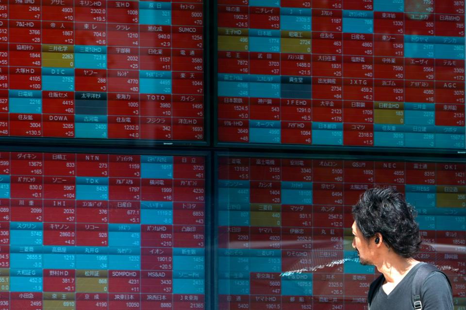 In this Aug. 9, 2019, photo, a man looks at an electronic stock board showing Japan's Nikkei 225 index at a securities firm in Tokyo. Asian shares were mostly higher Wednesday, Aug. 14, 2019 after the U.S. said it would hold off on tariffs of Chinese imports of mobile phones, toys and several other items typically on holiday shopping lists. (AP Photo/Eugene Hoshiko)