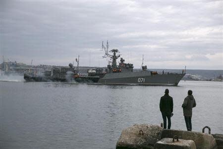 People watch a Russian Navy ship enter the Crimean port city of Sevastopol March 2, 2014. REUTERS/Baz Ratner