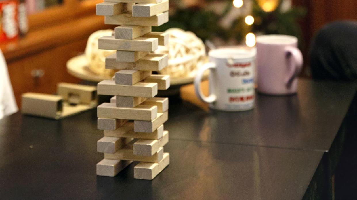 closeup of a set of stacked wooden blocks on the dining table next to the christmas tree