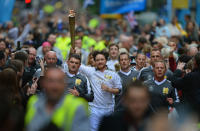 Actor James Mcavoy runs down Buchanan Street carrying the Olympic Torch during the leg between Stranrear and Glasgow on June 8, 2012 in Glasgow, Scotland. The Olympic torch arrived in Scotland last night to begin its tour of Scotland. The Olympic Flame is now on day 21 of a 70-day relay involving 8,000 torchbearers covering 8,000 miles. (Photo by Jeff J Mitchell/Getty Images)