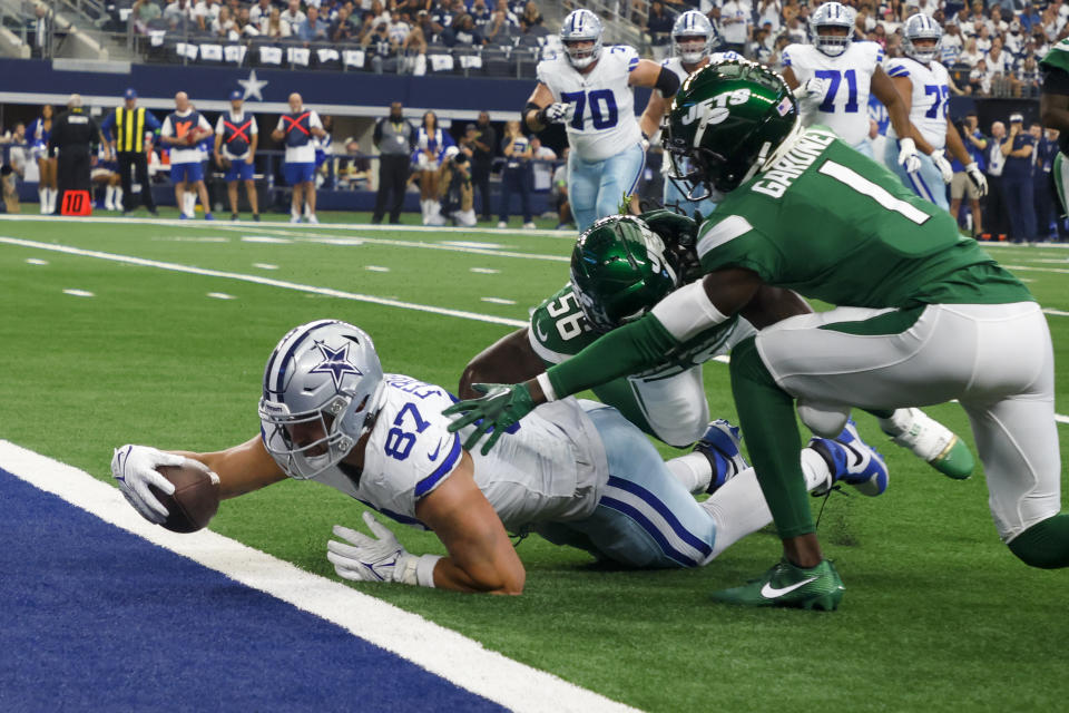 Dallas Cowboys tight end Jake Ferguson scores passes New York Jets cornerback Sauce Gardner and linebacker Quincy Williams during the first half of an NFL football game in Arlington, Texas, Sunday, Aug. 17, 2023. (AP Photo/Michael Ainsworth)