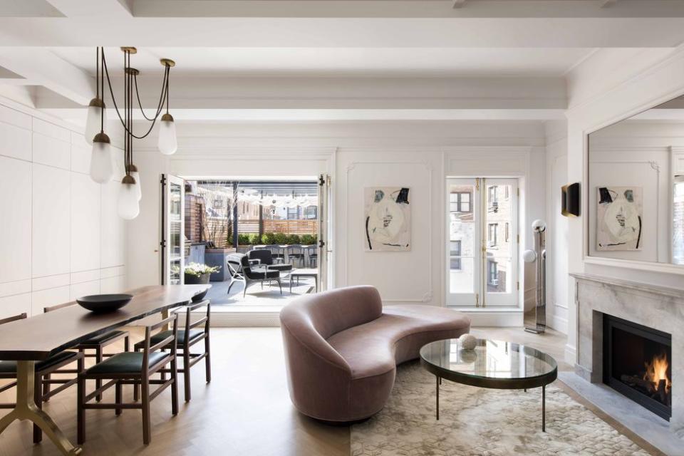 <p>The airy living room, featuring an ethanol fireplace, leads to the spacious terrace. In addition to white oak flooring with a herringbone pattern, new windows — in-swing French casements — were installed.</p>