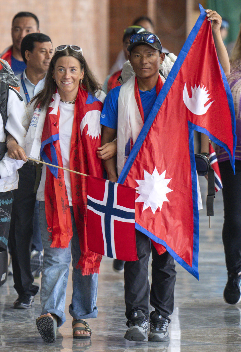 Norwegian climber Kristin Harila, left, and her Nepali sherpa guide Tenjen Sherpa, right, who climbed the world's 14 tallest mountains in record time, arrive in Kathmandu, Nepal, Saturday, Aug. 5, 2023. Harila and Sherpa shattered the record for the fastest climb of the 14 mountains more than 8,000 meters (about 26,000 feet) high when they topped Mount K2 in Pakistan late last month. The previous record was 189 days, and the pair did it in 92 days. (AP Photo/Niranjan Shrestha)