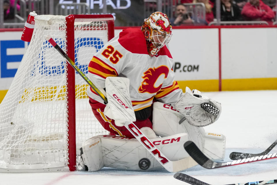 Calgary Flames goaltender Jacob Markstrom (25) deflects a shot in the first period of an NHL hockey game against the Washington Capitals, Monday, Oct. 16, 2023, in Washington. (AP Photo/Alex Brandon)