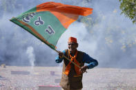 A Bharatiya Janata party (BJP) supporter celebrates lead for the party in Gujarat state elections in Gandhinagar, India, Thursday, Dec. 8, 2022. Indian Prime Minister Narendra Modi’s Hindu nationalist party is all set to keep its 27-year-old control of his home Gujarat state in a record state legislature win. (AP Photo/Ajit Solanki)