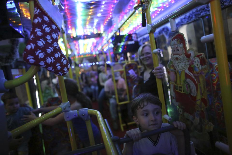 A boy looks at bus driver Edilson (not pictured), 45, also known as "Fumassa", inside an urban bus decorated with Christmas motives in Santo Andre, outskirts of Sao Paulo December 10, 2013. Fumassa dresses as Santa Claus every year while driving his bus. Picture taken December 10. REUTERS/Nacho Doce (BRAZIL - Tags: SOCIETY TRANSPORT)