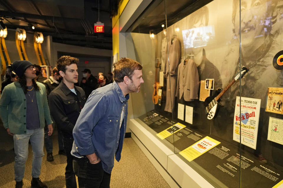 Caleb Followill, right, looks at a Beatles display at the Rock and Roll Hall of Fame Thursday, April 29, 2021, in Cleveland. Rockers Kings of Leon toured a new digital exhibit at the Rock and Roll Hall of Fame for the NFT (cryptocurrency) launching before the rock band plays at the NFL draft, Thursday, April 29, 2021, in Cleveland. (AP Photo/Tony Dejak)