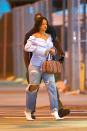 <p>In an off-the-shoulder button-down shirt, ripped jeans, white boots, gold necklace and Dior bag while out in New York. </p>