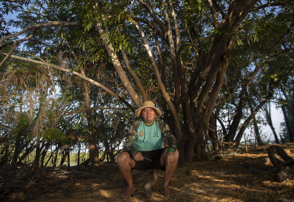 Fisherman Sandro Branco poses for a photo on teh banks of the Tapajos river in Alter do Chao, district of Santarem, Para state, Brazil, Thursday, Aug. 27, 2020. Dubbed "the Brazilian Caribbean," Alter do Chao, on the edges of the Tapajos River is facing growing environmental concerns. Real estate development, much of it illegal, flocks of tourists and neighboring ports exporting the country's soybeans and corn are affecting the lives of villagers and of an Indigenous group in the region. (AP Photo/Andre Penner)