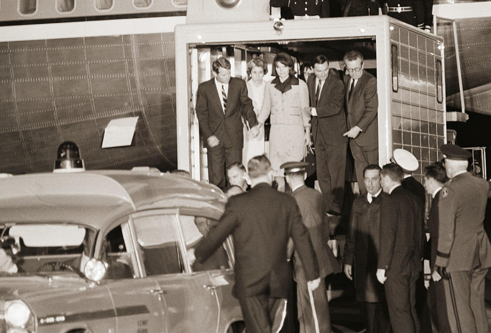 Jackie Kennedy exiting a building in the pink suit