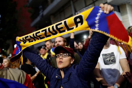 A woman holds a scarf as she gathers in support of Venezuela's opposition leader Juan Guaido outside the Embassy of Venezuela in Mexico City, Mexico January 23, 2019. REUTERS/Edgard Garrido