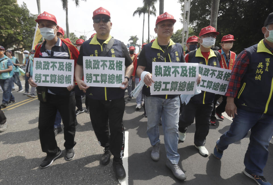 Taiwanese workers hold slogans reading "Failure to govern and workers will come settle the score" during a May Day rally in Taipei, Taiwan, Monday, May 1, 2023. Thousands of protesters from different labor groups protest on the street to ask for increasing labor welfare. (AP Photo/Chiang Ying-ying)