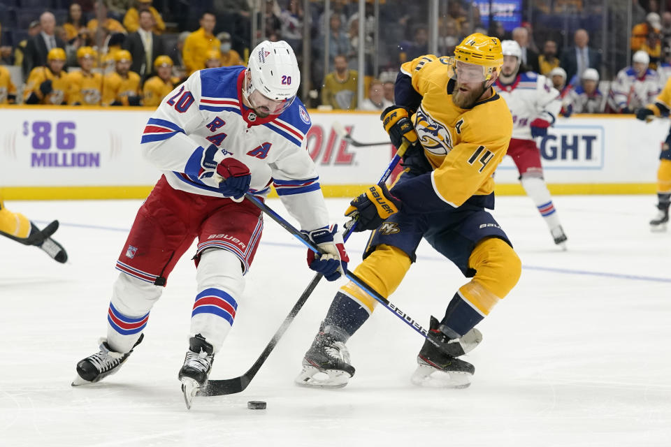 New York Rangers left wing Chris Kreider (20) and Nashville Predators defenseman Mattias Ekholm (14) battle for the puck in the first period of an NHL hockey game Thursday, Oct. 21, 2021, in Nashville, Tenn. (AP Photo/Mark Humphrey)