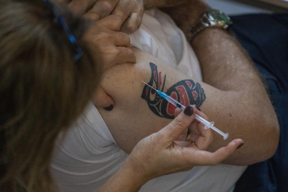 A medical staff member receives a COVID-19 coronavirus vaccine at the Ichilov Hospital in Tel Aviv, Israel, Sunday, Dec. 20, 2020. (AP Photo/Ariel Schalit)