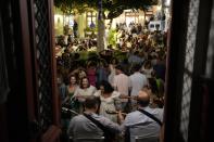 People dance during a festivity, known as Panigiri, on the Aegean Sea island of Tzia or Kea, Greece, early Tuesday, Aug. 16, 2022. The Dormition of the Virgin Mary (or Mother of God as the Greeks usually refer to her) is celebrated on Aug. 15. The religious event is coupled with midsummer festivities, known as Panigiria, that often last more than a day with music, culinary feasts and, in many cases, flea markets. (AP Photo/Thanassis Stavrakis)