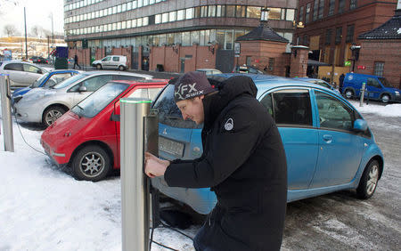 Are Paulsrud disconnects his electric car from a free recharging station in Oslo, Norway, February 21, 2013. REUTERS/Alister Doyle/File Photo