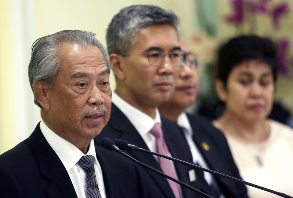 Malaysian Prime Minister Muhyiddin Yassin, left, speaks during a press conference at prime minister's office in Putrajaya, Malaysia, Monday, March 16, 2020. From March 18 till March 31, all business and religious activities in the country will be suspended to curb the spread of the coronavirus, said Prime Minister Muhyiddin Yassin. For most people, the new coronavirus causes only mild or moderate symptoms. For some it can cause more severe illness, especially in older adults and people with existing health problems. (AP Photo)