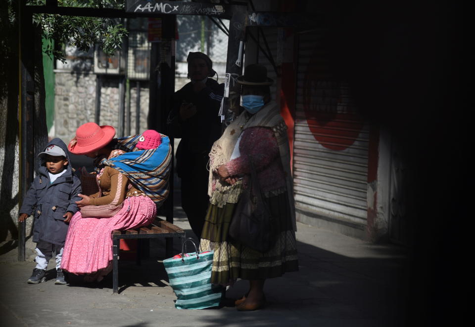 A woman and her children are seen on a street under high levels of ultraviolet (UV) radiation amid an unusual heatwave, in La Paz, Bolivia, November 2, 2021. REUTERS/Claudia Morales