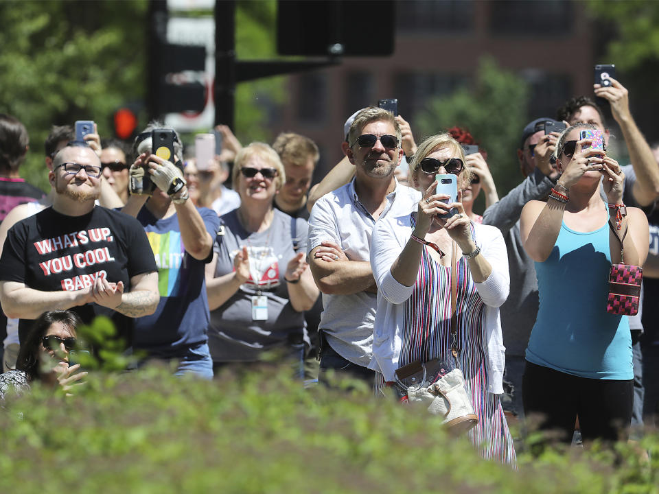 Spectators capture photos and applaud outside the Wisconsin State Capitol as a rainbow flag observing Pride Month is raised over the east wing of the building in Madison, Wis., Friday, June 7, 2019. The display, endorsed by Democratic Gov. Tony Evers, drew backlash from conservative Republican lawmakers who said it was divisive, while Democrats hailed it as a sign of inclusivity. (John Hart/Wisconsin State Journal via AP)