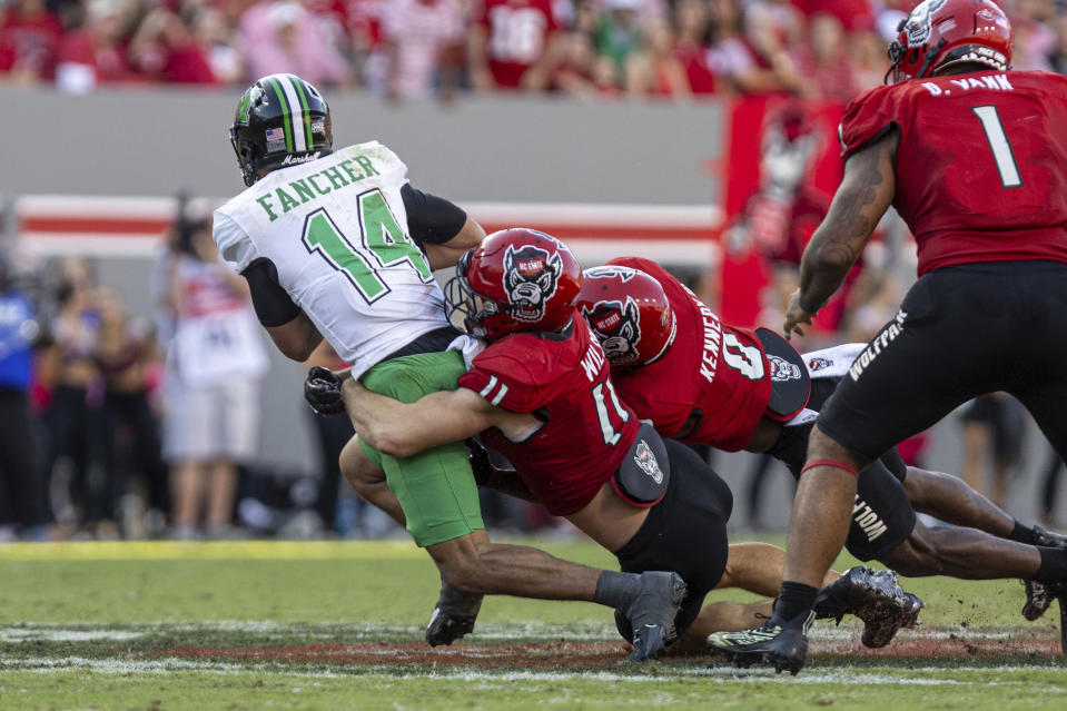 Marshall quarterback Cam Fancher is sacked by North Carolina State's Payton Wilson (11) during an NCAA football game on Saturday, Oct. 7, 2023, at Carter-Finley Stadium in Raleigh, N.C. (Sholten Singer/The Herald-Dispatch via AP)