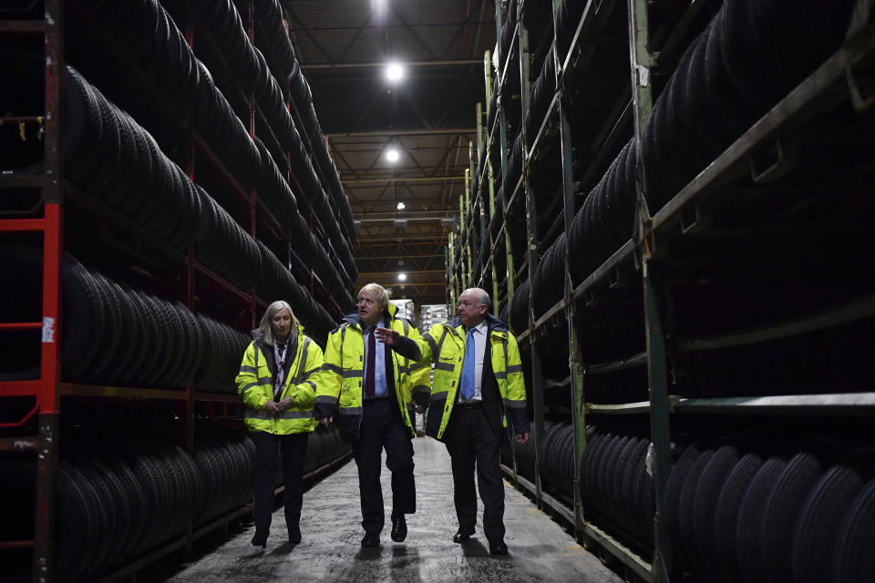Britain's Prime Minister Boris Johnson, centre, poses for a photo in a warehouse with CEO Alan Ferguson, right, and Conservative Parliamentary Candidate for Washington and Sunderland West Valerie Allen, during a General Election campaign visit to Fergusons Transport in Washington, England, Monday, Dec. 9, 2019. Britain goes to the polls on Dec. 12. (Ben Stansall/Pool Photo via AP)