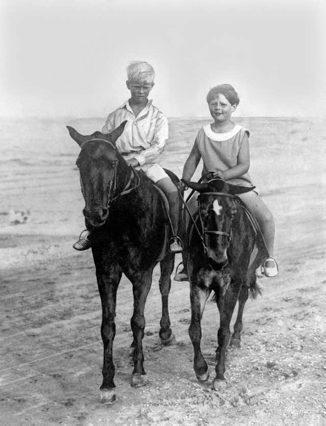 King Michael Of Romania, right, rides with his cousin Prince Philip of Greece on the sands at Constanza