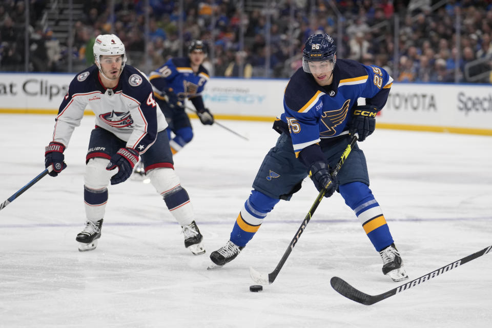 St. Louis Blues' Jordan Kyrou (25) controls the puck as Columbus Blue Jackets' Cole Sillinger (4) defends during the second period of an NHL hockey game Tuesday, Jan. 30, 2024, in St. Louis. (AP Photo/Jeff Roberson)